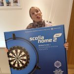 Scolia Home 2 Flex smart dartboard displayed with festive giveaway graphics and text showing “FREE Giveaway – Drawn December 31st.